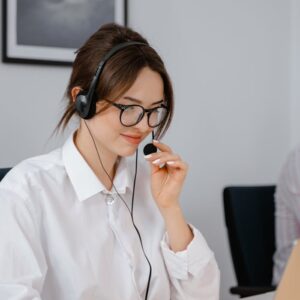 A Woman Wearing a Headset while Working on a Laptop